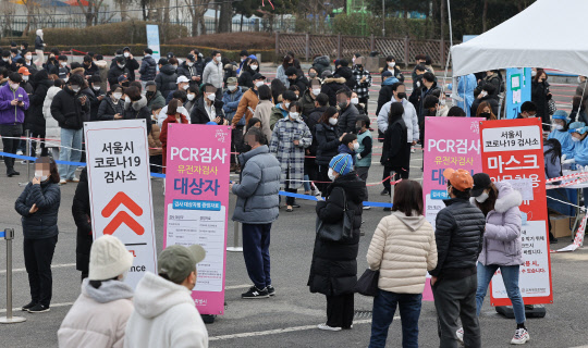 13일 오후 송파구 잠실종합운동장 제2주차장 선별진료소에서 시민들이 검사를 받기 위해 줄을 서있다.  중앙방역대책본부는 이날 0시 기준으로 코로나19 확진자가 5만4941명 늘어 누적 129만4205명이라고 밝혔다.   연합뉴스